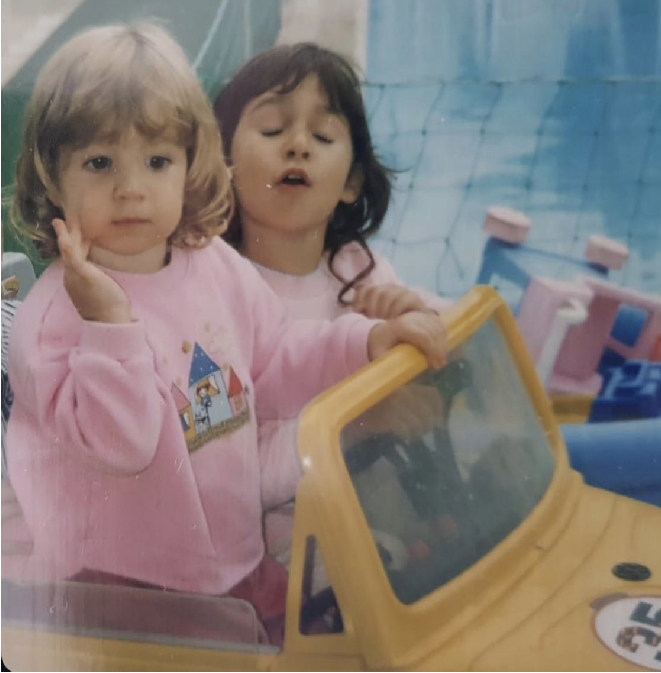 Lara as a child in a toy car